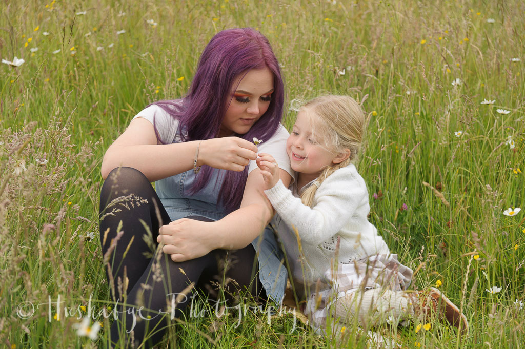 Big sister giving little girl a flower